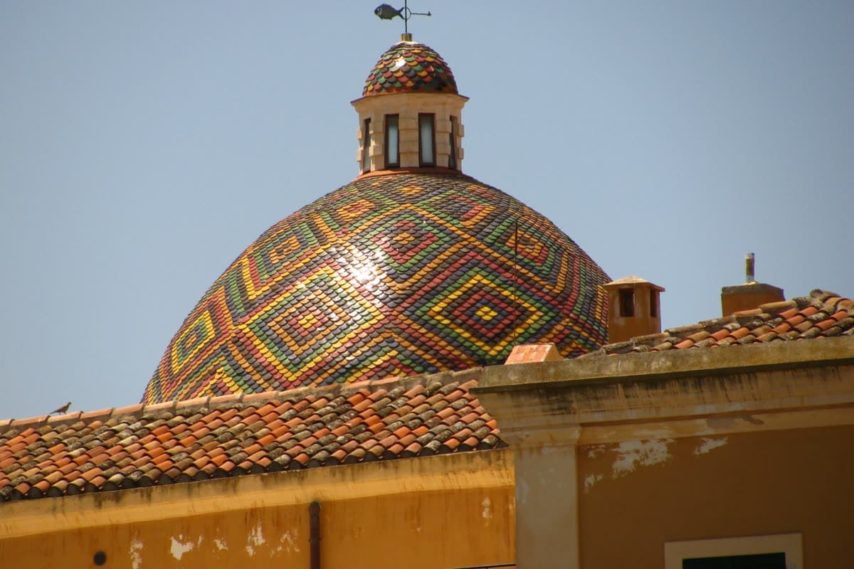The polychrome majolica dome of the church of San Michele in Alghero, patterned in green, yellow and blue