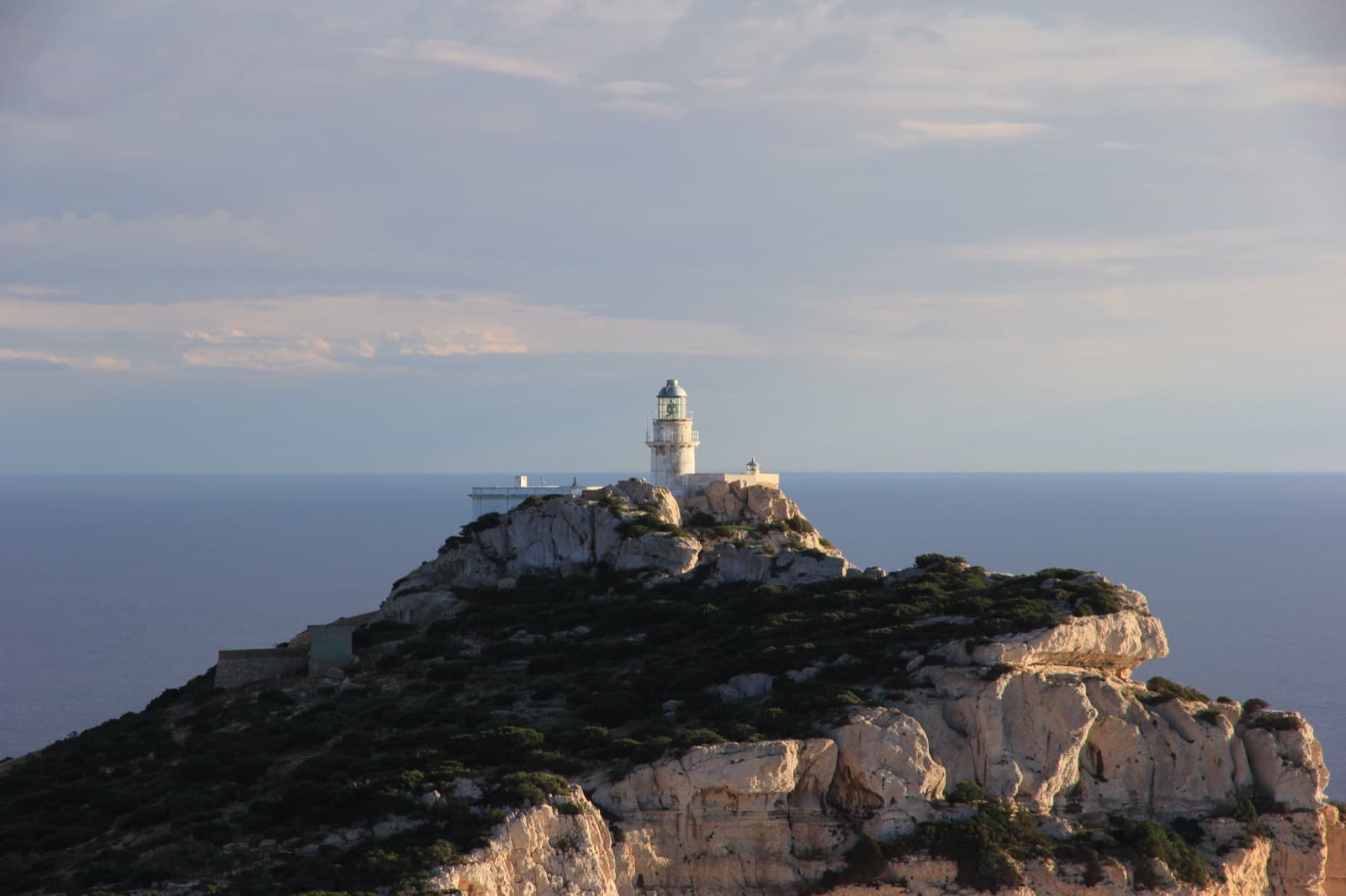 Lighthouse on the white cliffs of Capo Caccia above the sea