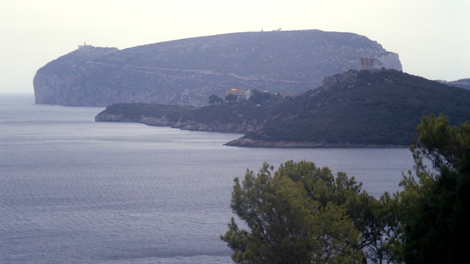 Il promontorio di Capo Caccia visto attraverso la baia di Porto Conte, falesie bianche a picco sul mare