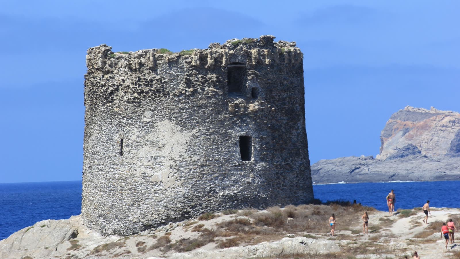 La torre della Pelosa sul suo isolotto davanti a Stintino, acqua turchese bassa e l'Asinara sullo sfondo