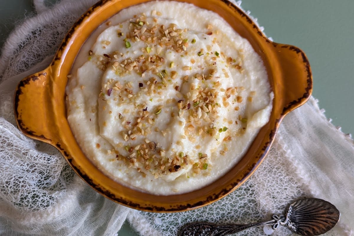Biancomangiare in a terracotta bowl, the white cream topped with chopped pistachio