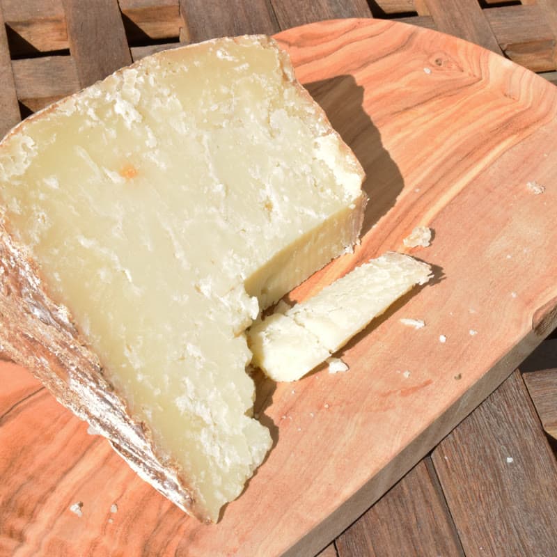 A cut wheel of Sardinian pecorino on a wooden board