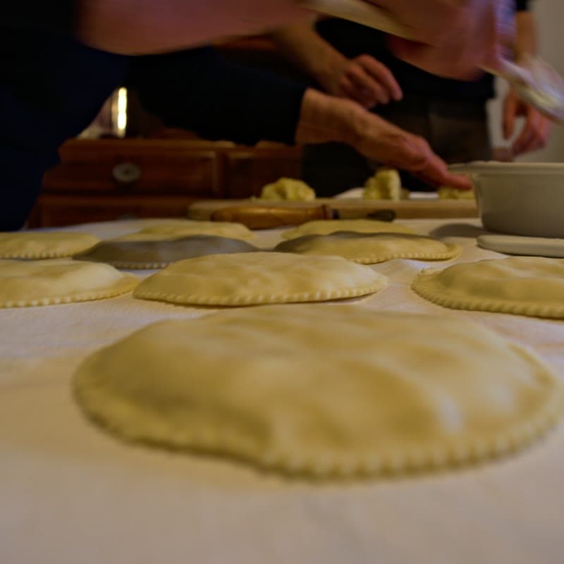 Discs of pastry laid out on a table during the home preparation of seadas