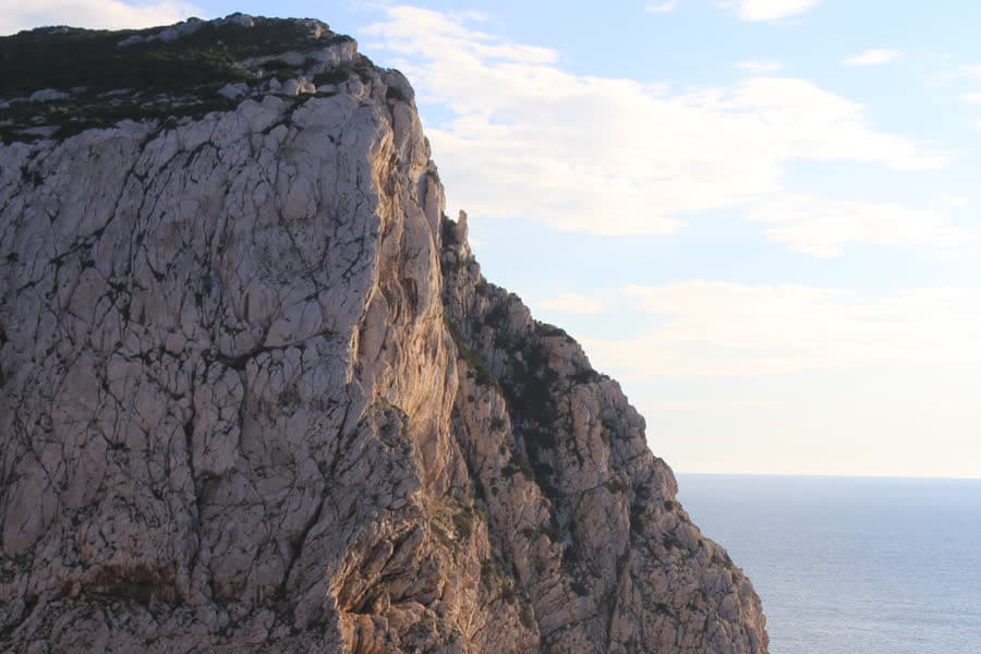 A vertical limestone wall at Capo Caccia dropping straight into the sea.