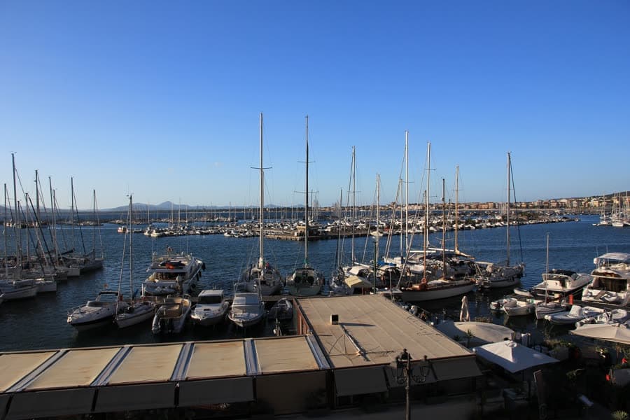 Yachts moored along the pontoons of Alghero's marina.