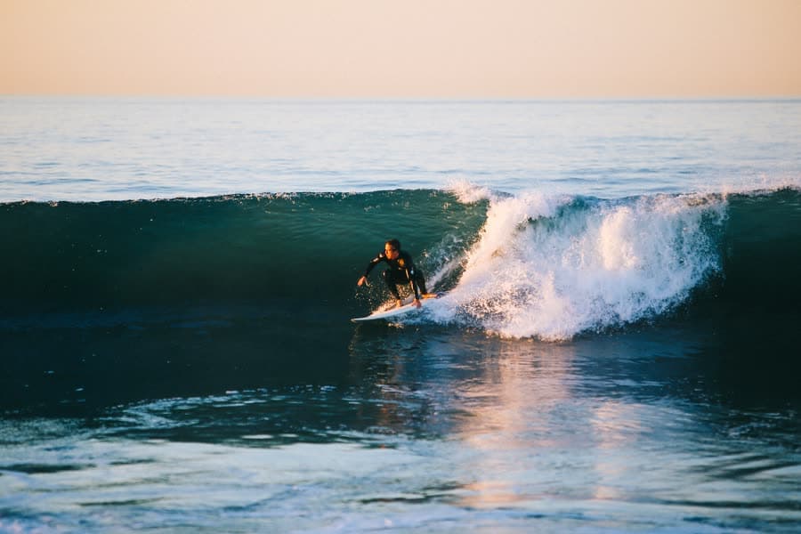 A surfer riding along the face of a breaking wave.