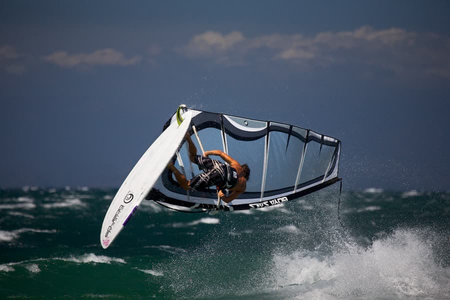A windsurfer lifting clear of the water in a strong breeze off Sardinia.