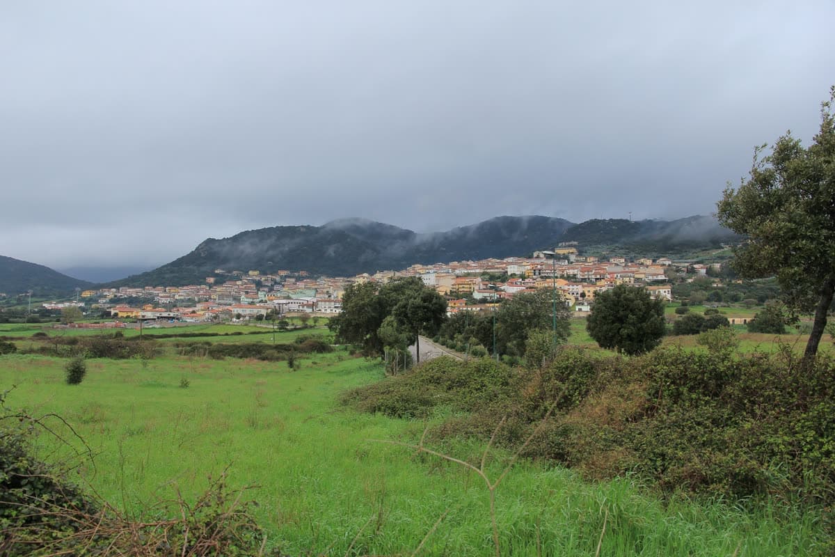 開けた土地の向こうに見えるベルキッダの村と、その奥のリンバラ山地